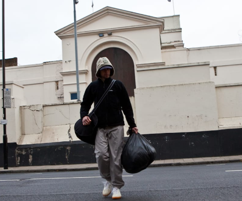 man leaving prison with trashbags